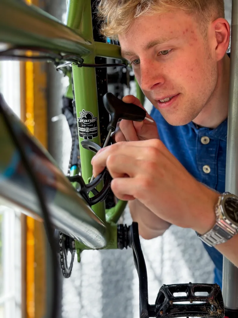 Callum inspecting the headset and front of a mountain bike.